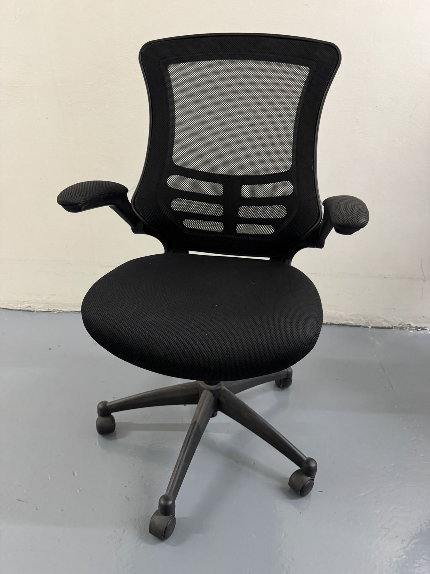 Black mesh ergonomic office chair with adjustable armrests.