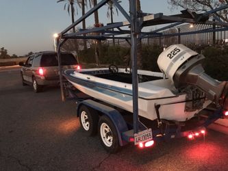 Custom boat trailer with jet ski rack includes boat and motor.