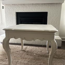 Vintage solid wood end table in antique white.