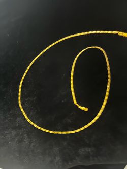 Elegant gold chain necklace is a bright yellow color with a textured link design. This piece has a lobster claw clasp for secure fastening.