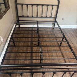 Black metal full size headboard and footboard single platform mattress base.