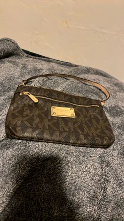 This is a MICHAEL Michael Kors Jet Set Large Signature Wristlet Wallet in brown coated canvas. 