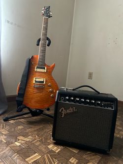 single-cutaway, Les Paul-style electric guitar and Fender Champion 20, amp