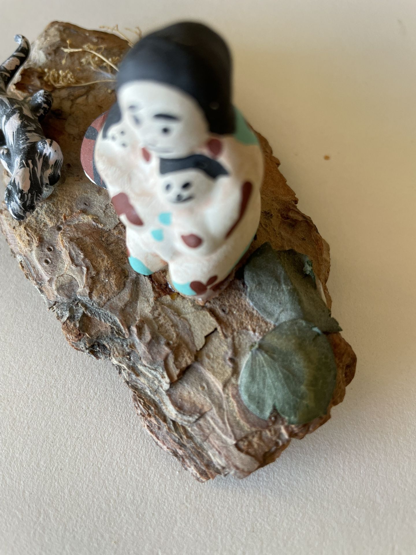 Native American Pottery Figures Displayed On Piece Of Bark