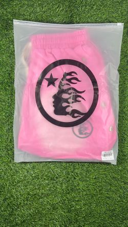 pink shorts with black circular logo featuring a flaming face and star