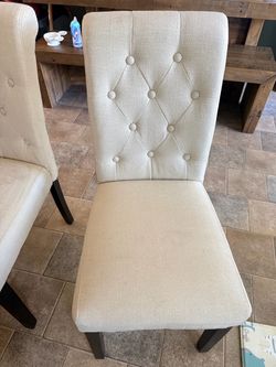 Two beige dining chairs