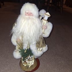 Santa Dressed in Gold holding a Clock & Toy Bag