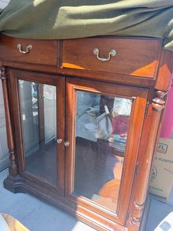 Thomasville Cabinet with Double Glass  Doors and a drawer, glass bevel shelf with mirror in back.