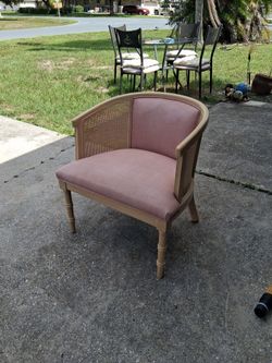 cane back barrel chair features a light-colored wood frame and pink linen upholstery