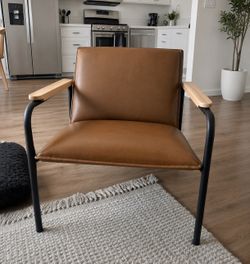 Modern mid-century lounge chair, camel-colored, leather-like seat