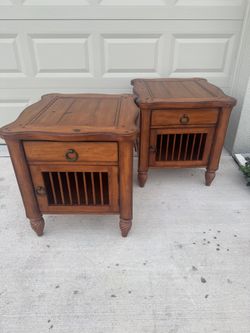 Two matching solid wood nightstands with pedestal feet