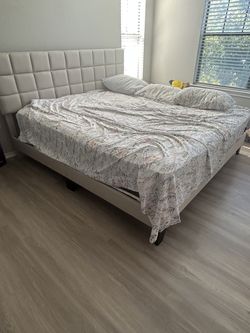 King size bed with pillows, bedsheets, and wooden frame