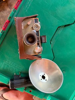 Vintage Argus C3 Matchmatic 35mm camera with its matching flash and leather case attached