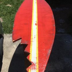 Solid wood hand crafted surfboard with shark bite