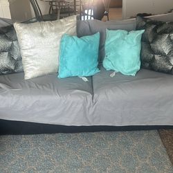 Two black couches and two end tables