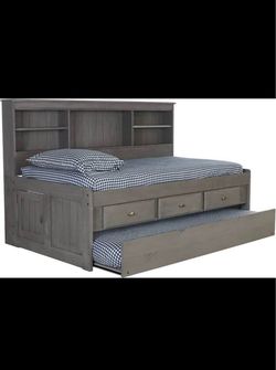 Full-size captain daybed with bookcase headboard, three drawers and twin trundle. Twin mattress included