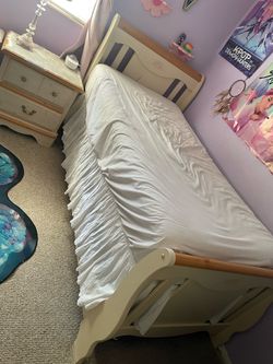 Single bed with mattress, box spring, and a small nightstand.