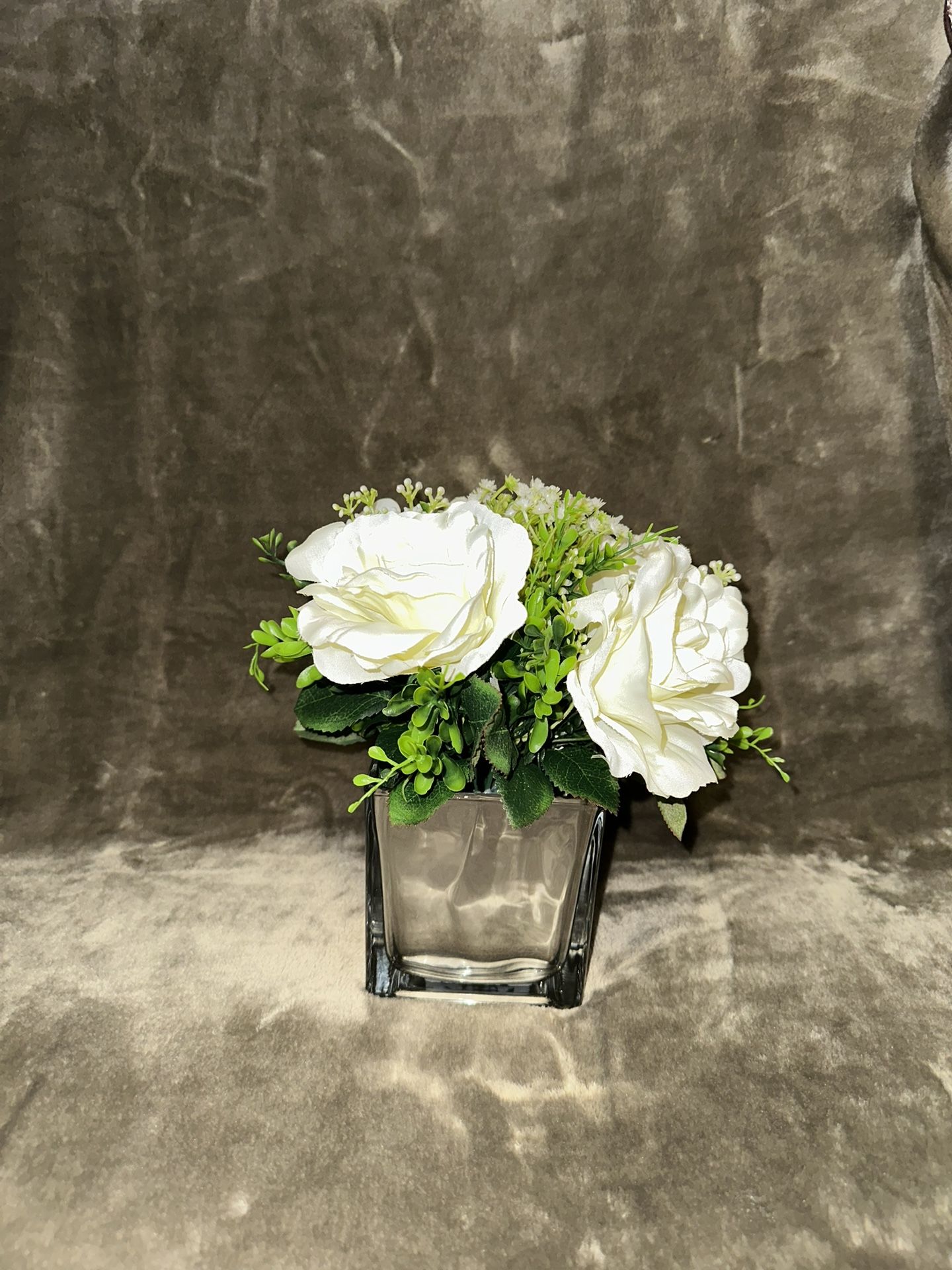 small artificial flower arrangement in a glass vase