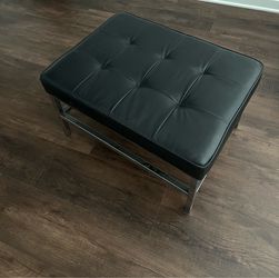 Black ottoman / metal frame .
