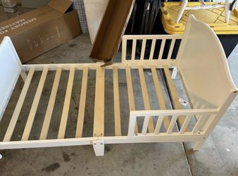 White wooden toddler bed with mattress
