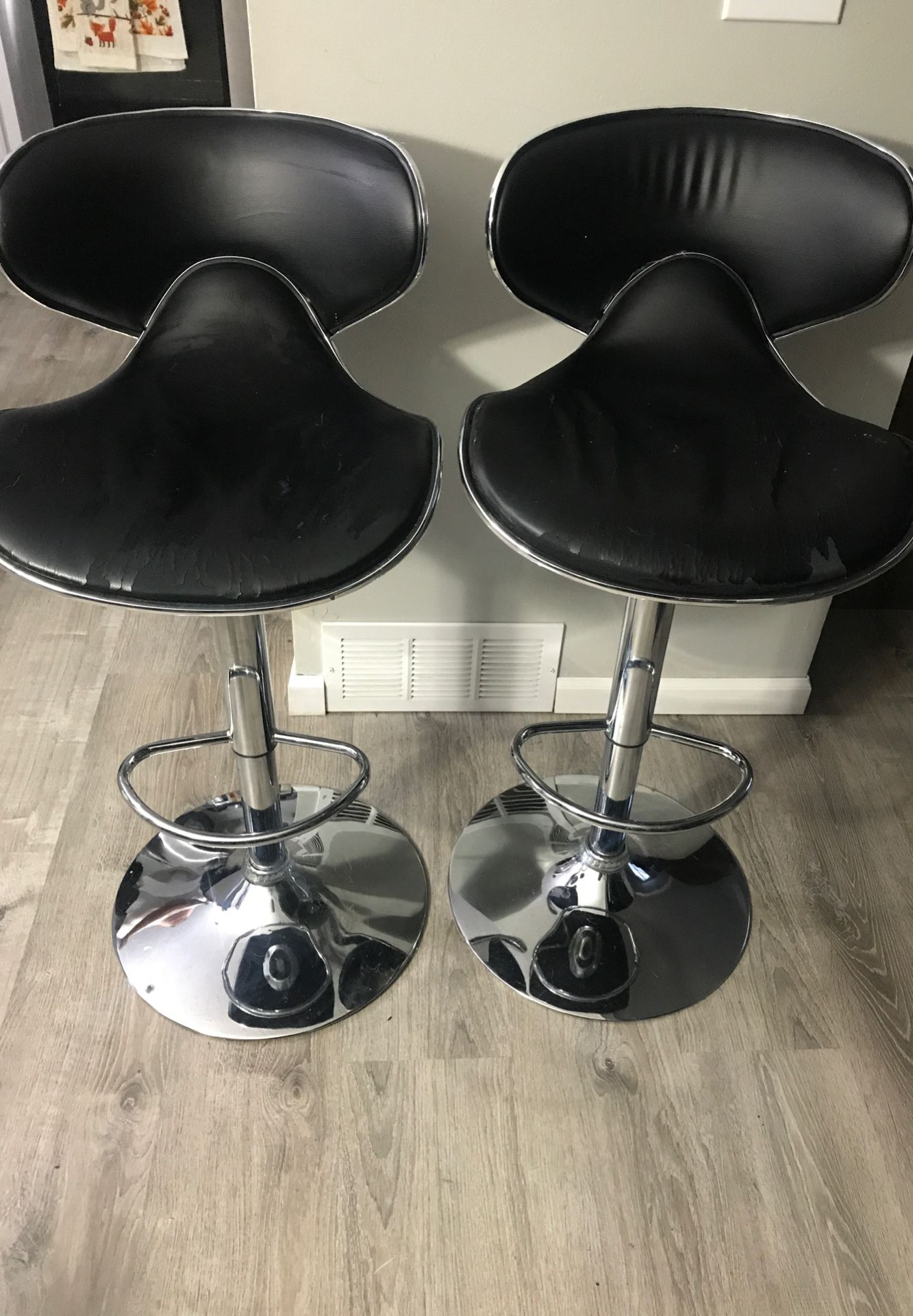 2 black and silver bar stools .Slight damage on seat part. Can adjust height.