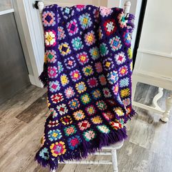 Vintage handmade granny square 58” x 42” blanket/throw with fringe. Purple with multi retro colored granny squares. 