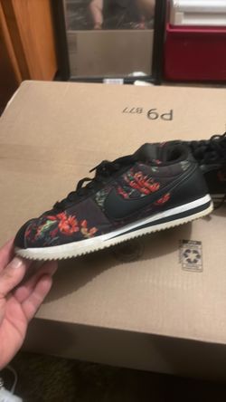 These are Nike Cortez Basic "Floral Pack" sneakers in black with red floral details.