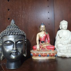 Set of three Buddha statues in various styles and colors.