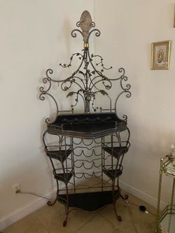 Vintage French-style wrought iron and brass bakers rack or wine rack with a decorative leaf and grape motif.