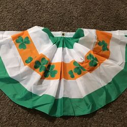 Green Foil Curtain And Two Clover Table Decorations