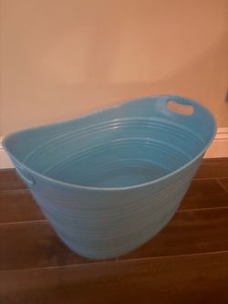 Large blue plastic oval utility tub featuring built-in side handles and horizontal ribbed detailing