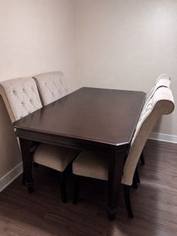 Dark wood table with beige chairs
