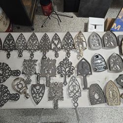 Large Collection Of Trivets Stands And Sad Irons.