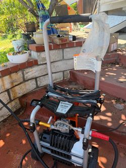 Electric Husqvarna PW 2000 pressure washer with a maximum pressure of 2000 PSI and a flow rate of 1.2 GPM. This orange and black unit has a wheeled me