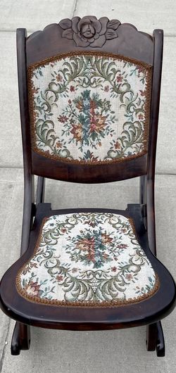 Vintage folding rocking chair with cushioned floral tapestry seat and backing