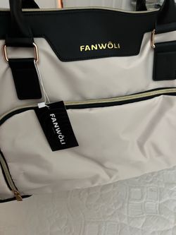 FANWÔLI beige and black nylon duffle bag featuring gold-tone hardware and top handles.