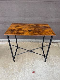 Compact desk with a rustic brown wood-tone top and black metal legs