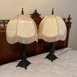 Pair Victorian-style table lamp ornate dark metal base and scalloped cream brocade shade w/ fringe trim  Nice working condition   PICK UP IN DEER PARK