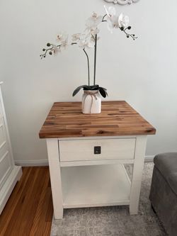 White bedside table with butcher block top and a single drawer