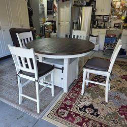 Kitchen / dining table with storage and four chairs.