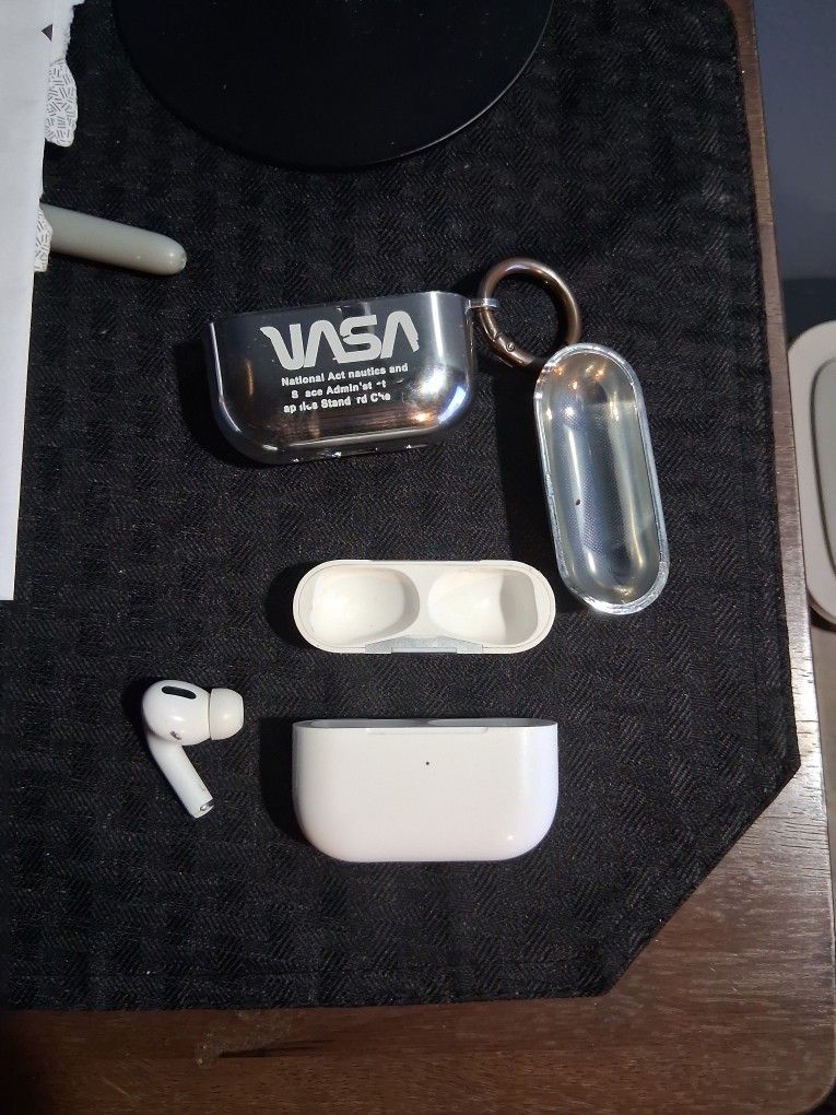 Left Air Pod Pro with charging case and plastic NASA case.
