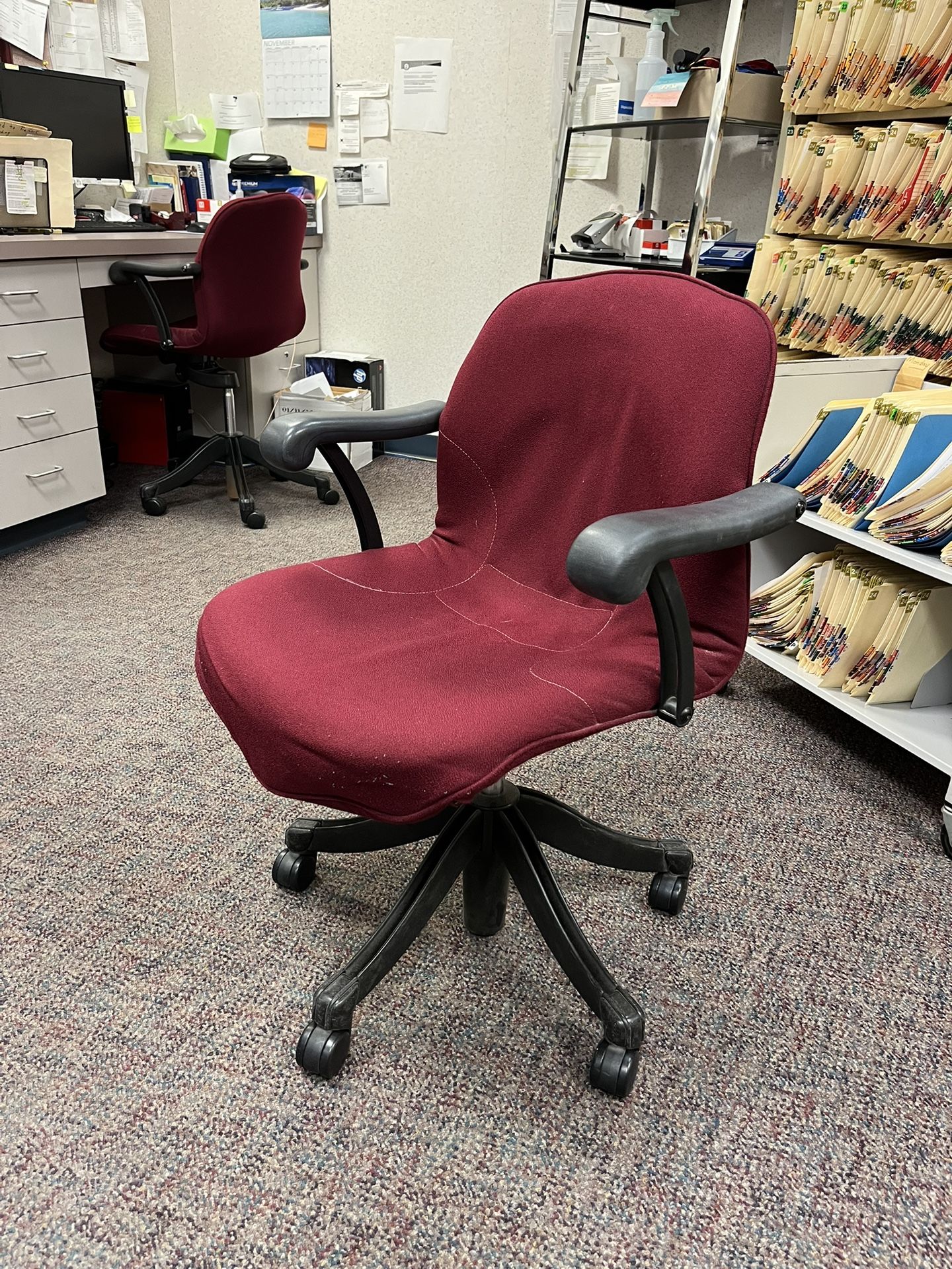 Rolling red and black, pneumatic adjustable height chair. Perfect for an office or nonprofit.