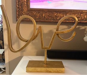Gold decorative tabletop sign mounted on a matching rectangular metal base.