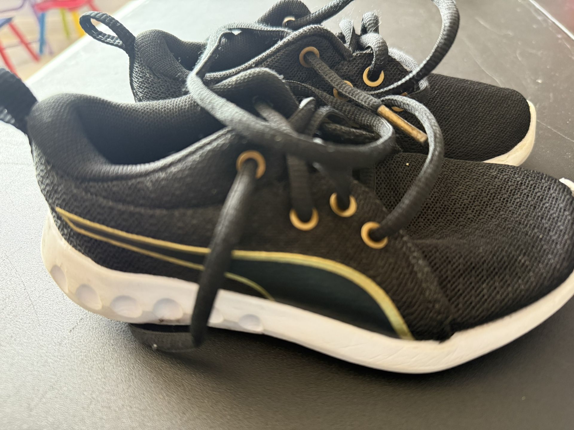 Puma Black and Gold Sneakers with Curved Stripe Design