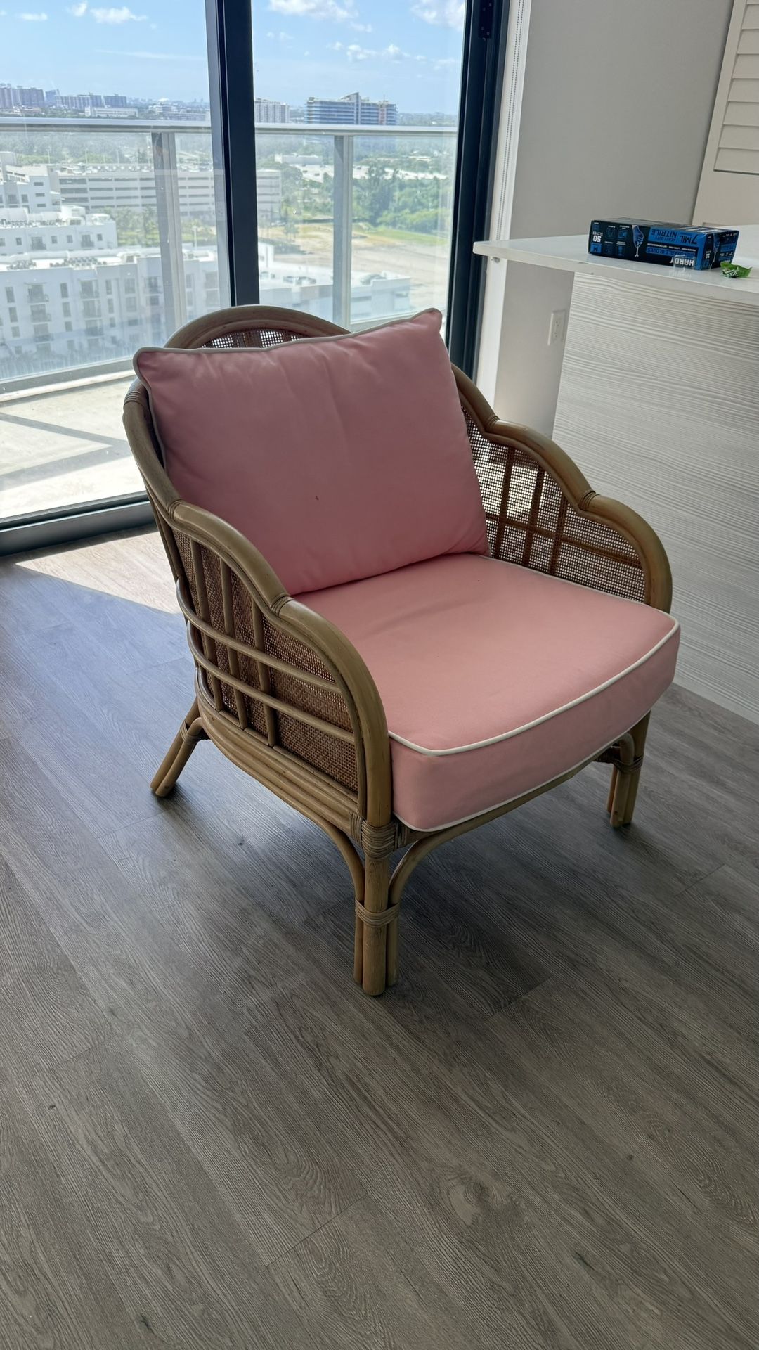 2 rattan lounge chais with pink cushions.