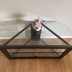 Modern glass coffee/TV table with a geometric black metal base—Clean condition