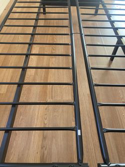 Futon base is of metal and the hand rests are of solid wood