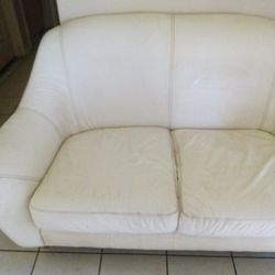white or beige  leather two seat couch
