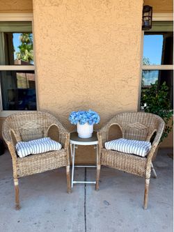 Two rattan wicker patio chairs Nancy Meyers style
