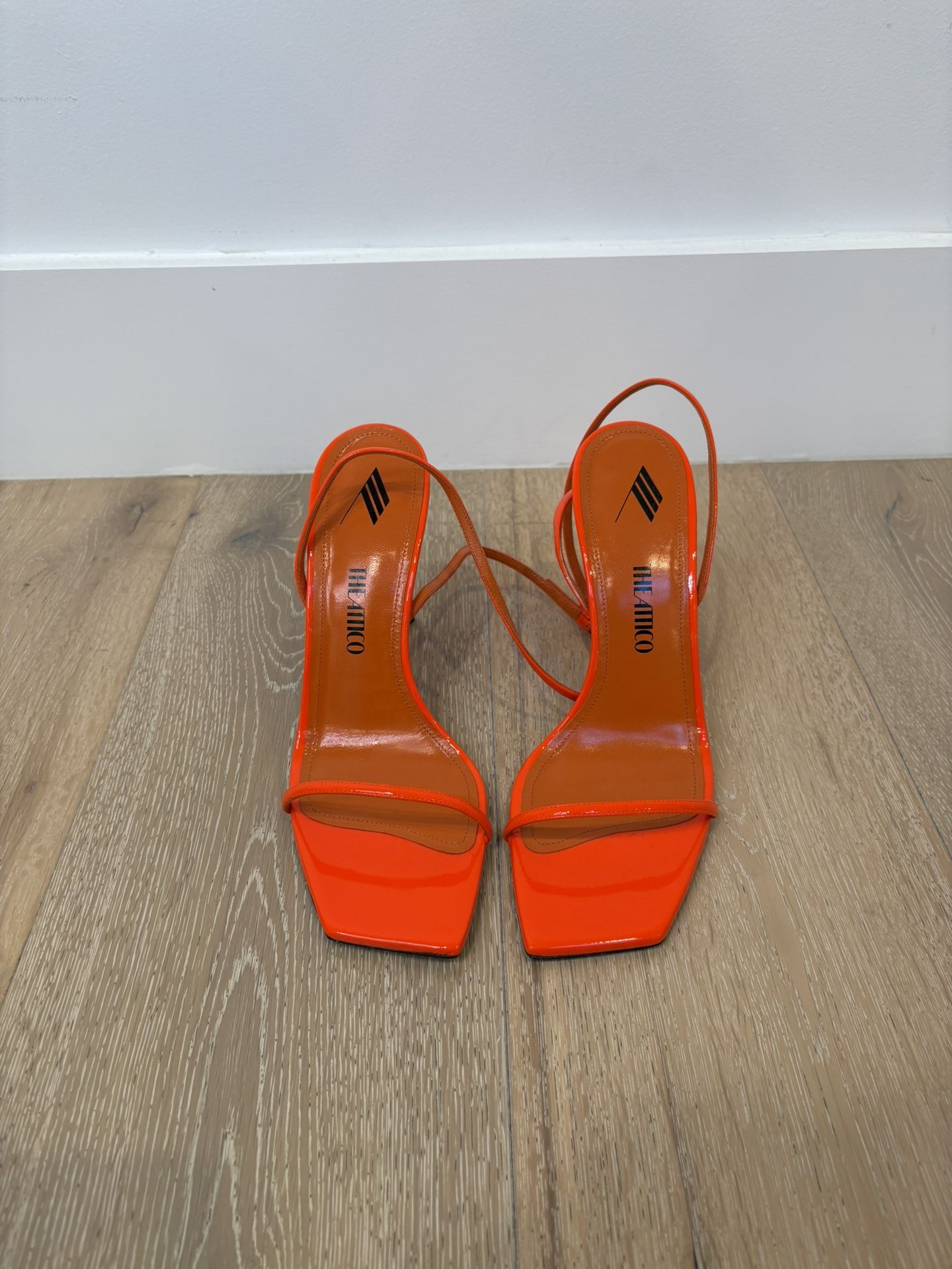 The Attico Ankle Strap Sandals in a neon orange color